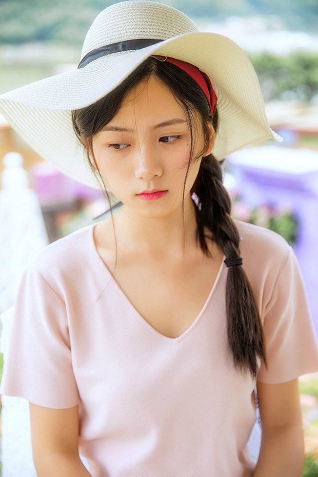 花园中的草帽沉思女生图片