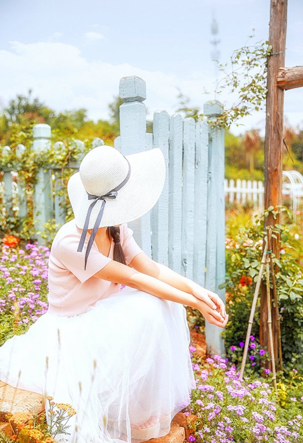 花园中的草帽沉思女生图片